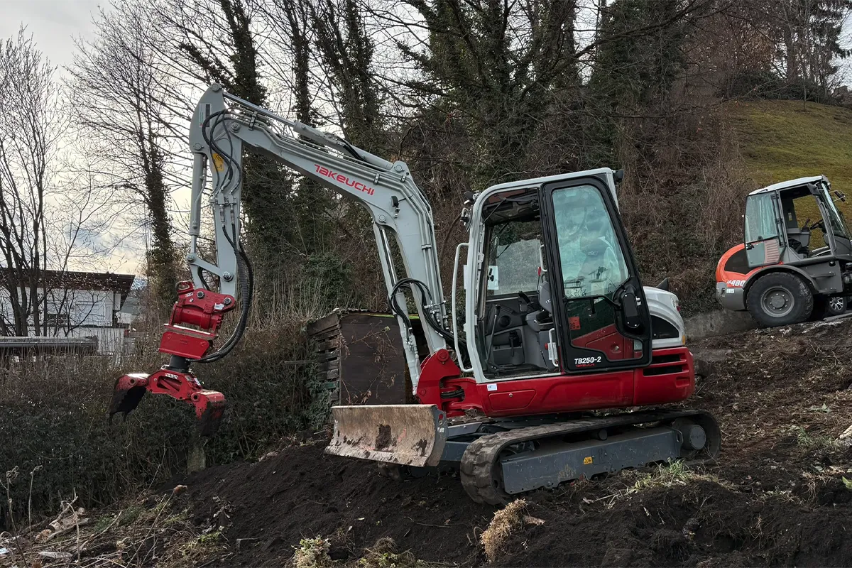 Bagger mit Greifer bei Arbeiten auf unebenem Gelände Bagger mit Greifer bei Arbeiten auf unebenem Gelände