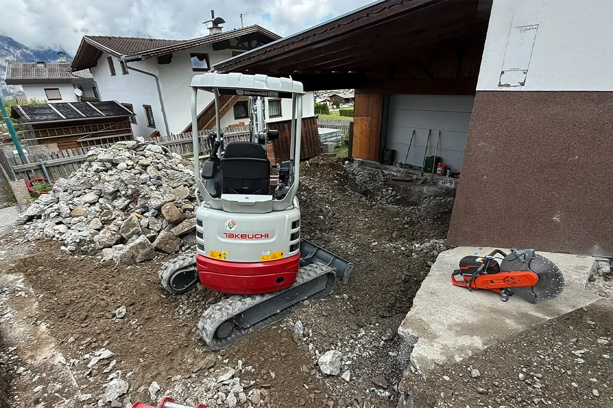 Minibagger bei Erdarbeiten für Außenanlagen neben einem Wohnhaus Minibagger bei Erdarbeiten für Außenanlagen neben einem Wohnhaus